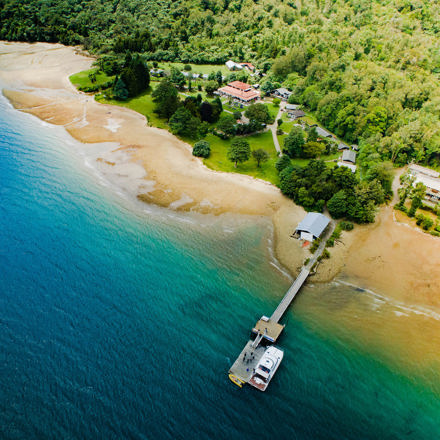 Aerial view of Furneaux Lodge across Endeavour Inlet and the jetty in the Marlborough Sounds, at the top of New Zealand's South Island.