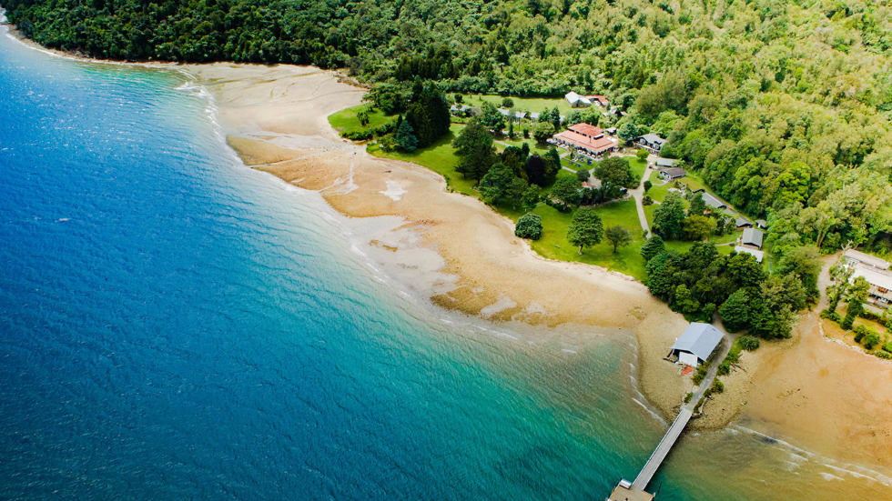 Aerial view of Furneaux Lodge across Endeavour Inlet and the jetty in the Marlborough Sounds, at the top of New Zealand's South Island.