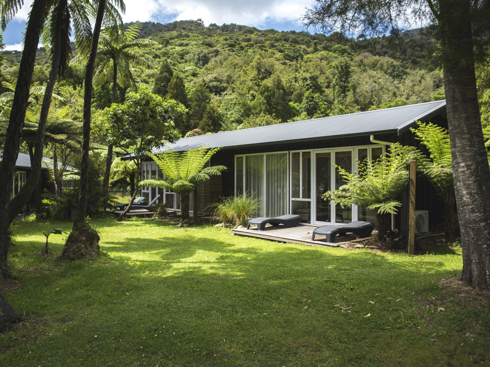 An Endeavour Suite is surrounded by native bush and lush greenery at Furneaux Lodge in the Marlborough Sounds, New Zealand.