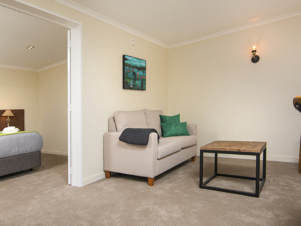 A Tobias Junior Suite living area is situated close to the bedroom area at Furneaux Lodge in the Marlborough Sounds, New Zealand.