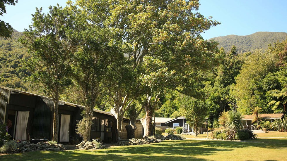 Hiker's Cabins lined up with Tobias Suites and Cook's Cottages in the background at Furneaux Lodge in the Marlborough Sounds at the top of New Zealand's South Island.