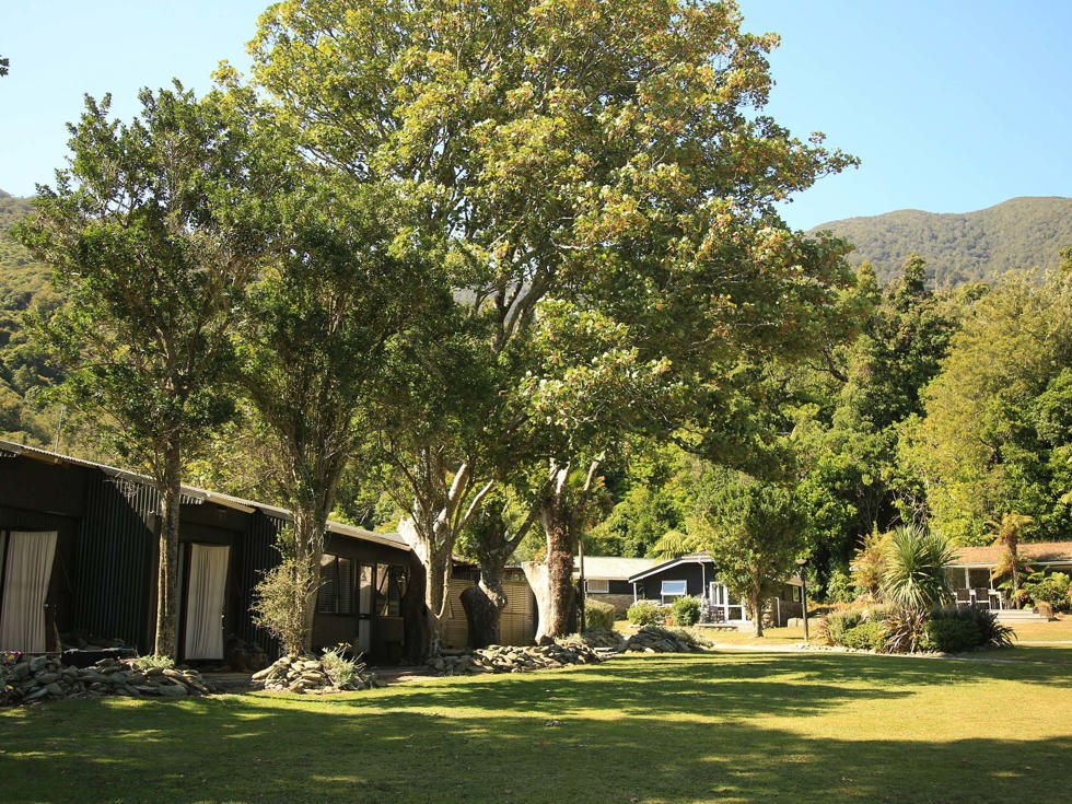 Hiker's Cabins lined up with Tobias Suites and Cook's Cottages in the background at Furneaux Lodge in the Marlborough Sounds at the top of New Zealand's South Island.