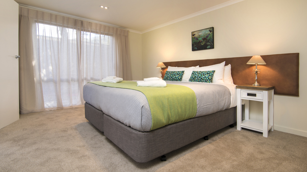 A side view of the bedroom area in a Tobias Junior Suite at Furneaux Lodge in the Marlborough Sounds, New Zealand.