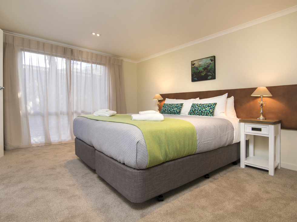 A side view of the bedroom area in a Tobias Junior Suite at Furneaux Lodge in the Marlborough Sounds, New Zealand.