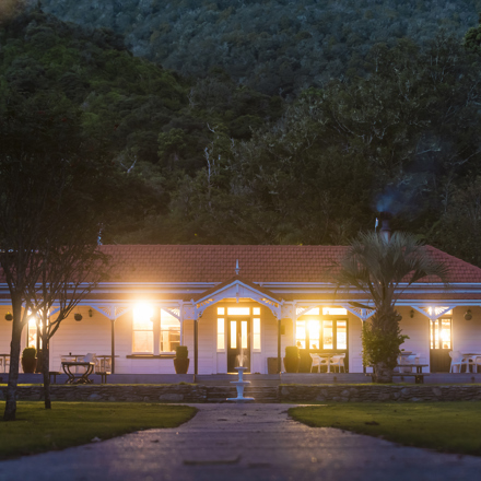 The front of historic Howden House at Furneaux Lodge showing the long verandah and orange tiled roof, in the Marlborough Sounds at the top of New Zealand's South Island.