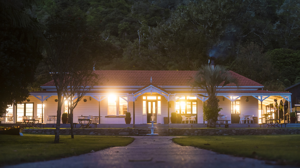 The front of historic Howden House at Furneaux Lodge showing the long verandah and orange tiled roof, in the Marlborough Sounds at the top of New Zealand's South Island.