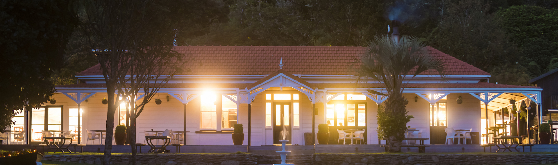 The front of historic Howden House at Furneaux Lodge showing the long verandah and orange tiled roof, in the Marlborough Sounds at the top of New Zealand's South Island.