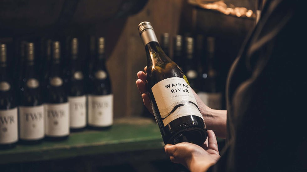 A bottle of Wairau River Sauvignon Blanc is chosen from the Restaurant and Bar wine cellar at Furneaux Lodge in the Marlborough Sounds, New Zealand.