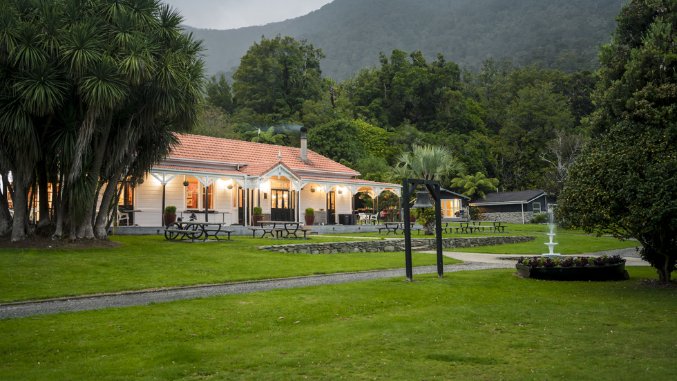 The front of historic Howden House with orange tiled roof and lawn in front, in the Marlborough Sounds at the top of New Zealand's South Island.