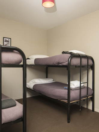 A Hiker's Cabin bunk room with 2 sets of bunk beds at Furneaux Lodge in the Marlborough Sounds, New Zealand.