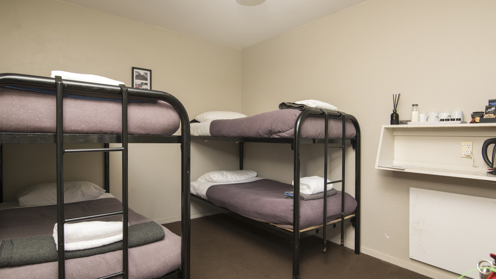 A Hiker's Cabin bunk room with 2 sets of bunk beds at Furneaux Lodge in the Marlborough Sounds, New Zealand.