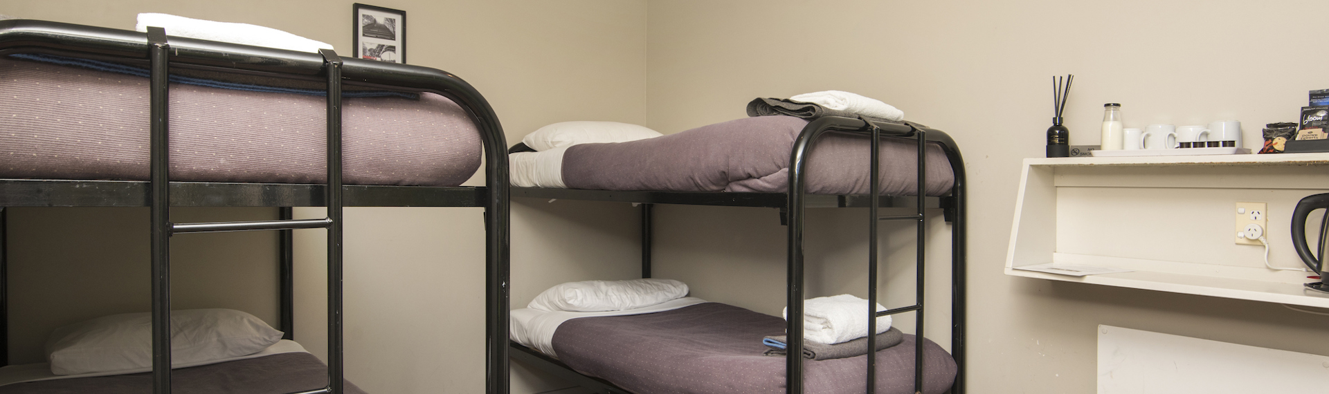 A Hiker's Cabin bunk room with 2 sets of bunk beds at Furneaux Lodge in the Marlborough Sounds, New Zealand.